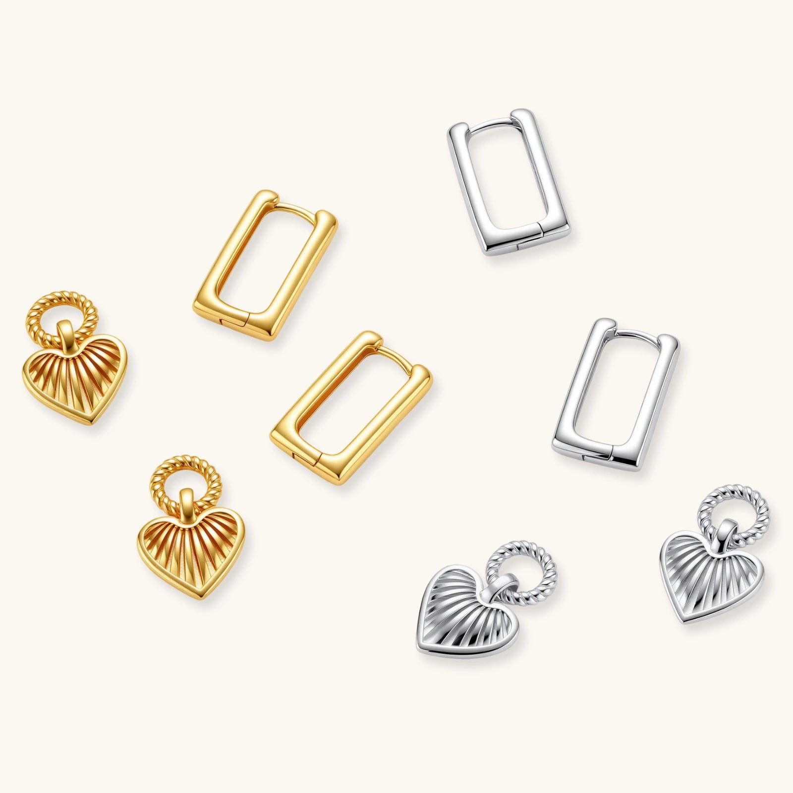 Gold-plated huggie earrings with textured heart charms featuring radiating sunburst patterns on white background.